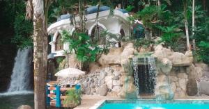 a swimming pool in a resort with a waterfall at Kashama Eco Resort & Spa in Santo Domingo de los Colorados