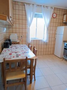a kitchen with a table with chairs and a window at Bonito apartamento Cistierna in Cistierna