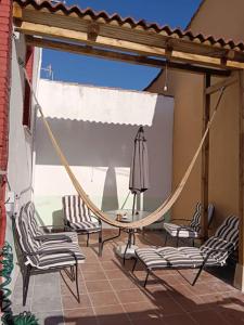 um alpendre com cadeiras e uma rede de descanso num pátio em Bonito apartamento Cistierna em Cistierna