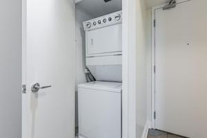 a kitchen with a stove and a washer and dryer at Fort York Apartments in Toronto