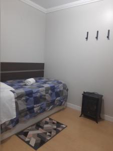 a bedroom with a bed and a table with a rug at Solar das Esmeraldas - Apto 105 in Gramado