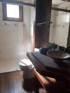 a bathroom with a sink and a toilet and a shower at Solar das Esmeraldas - Apto 105 in Gramado