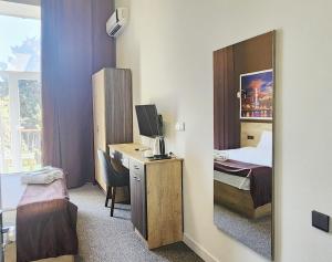 Zimmer mit einem Schreibtisch und einem Spiegel in der Unterkunft ELYSIUM HOTEL in Baku