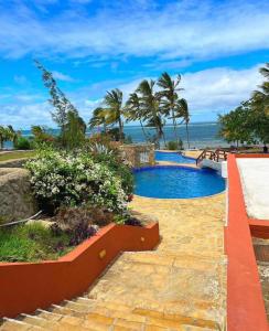 a swimming pool with a view of the ocean at SANDS AND ROCKS APARTMENT in Mombasa