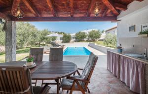 a patio with a table and chairs and a swimming pool at Villa Viktoria poll&garden view in Kaštelir +18 photos