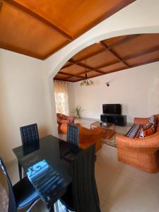 - un salon avec une table, des chaises et un canapé dans l'établissement Nicole Residence, à Yaoundé