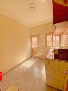 an empty kitchen with a tile floor and windows at Nicole Residence in Yaoundé