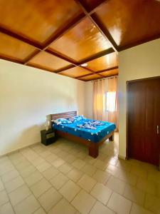 ein Schlafzimmer mit einem blauen Bett in einem Zimmer in der Unterkunft Nicole Residence in Jaunde