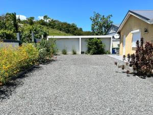 a driveway of a house with flowers in front of it at Villa marigua 2 in Les Abymes