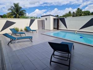 a patio with a pool and two chairs and a swimming pool at Villa marigua 2 in Les Abymes