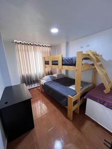 a bedroom with two bunk beds and a table at Alegre House in Lima