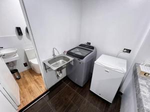 a small bathroom with a sink and a trash can at Alegre House in Lima