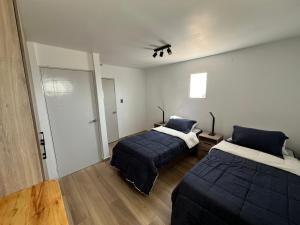 1 dormitorio con 2 camas y armario con puerta en AH alojamientos, en Antofagasta