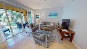 a living room with a couch and a television at Villa Renaissance in Grace Bay
