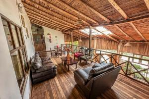 a living room with leather furniture and a balcony at ART HOUSE Hacienda San Antonio in Cajamarca