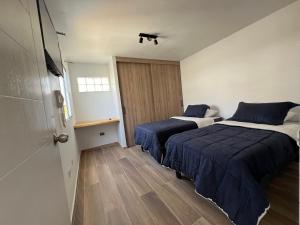- une chambre avec 2 lits et une porte lumineuse dans l'établissement AH alojamientos, à Antofagasta