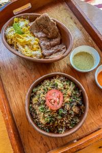 una mesa de madera con dos tazones de comida. en ART HOUSE Hacienda San Antonio, en Cajamarca