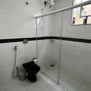 uma casa de banho com um WC e uma cabina de duche em vidro. em Pousada Pé na Areia Rio das Ostras em Rio das Ostras