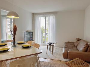 uma sala de estar com uma mesa e um sofá em Charmantes Apartment inmitten Zürich-Affoltern & Netflix! em Zurique