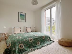 a bedroom with a bed and a large window at Charmantes Apartment inmitten Zürich-Affoltern & Netflix! in Zurich