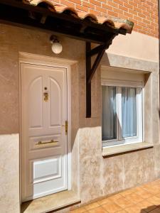 a white door and a window on a brick wall at Villa Manuela in Candás