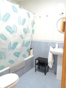 Un baño con una cortina de ducha con hojas de palma. en AMPLIO, LUMINOSO Y MODERNO II, en Calasparra