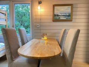 una mesa de madera y sillas en un comedor en Kveldsro cabin in nice surroundings en Kristiansand