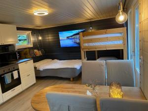 Kveldsro cabin in nice surroundings في كريستيانساند: غرفة مع طاولة طعام وسرير بطابقين