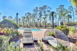 a patio with two chairs and a pool at Bright Condo - 2BR with Pool & Hot Tub, near Disney! in Orlando