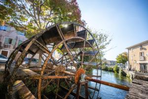 a roller coaster sitting on the side of a river at Le Triplex - 8 pers - Hypercentre - Wifi in LʼIsle-sur-la-Sorgue