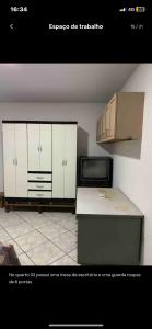 cocina con armarios blancos y microondas en Casa - Família Hassan, en Corumbá