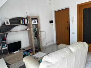 un salon avec un canapé blanc et une télévision dans l'établissement Emy Wine house, à Porto Recanati