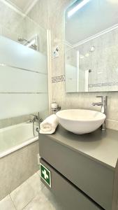 uma casa de banho com um lavatório, um espelho e uma banheira em PRAIA DA ROCHA, 4ºB Jardins da Rocha, Charming Studio, near the Sea, By IG em Portimão