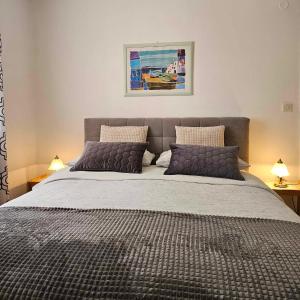 una camera da letto con un grande letto con due cuscini di Apartmani Rita Kiwi a Novigrad Istria