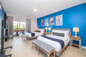 奧蘭多的住宿－Luxury Disney Themed Condo - Pool & Private Patio，一间卧室设有两张床和蓝色的墙壁