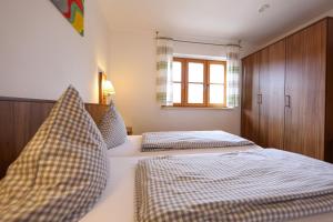 1 dormitorio con 2 camas y ventana en Ferienwohnungen auf dem Paulbauernhof en Triebenbach