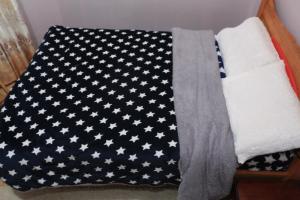 a black and white blanket with white stars on it at Chaka Furnished Apartments in Kiganjo