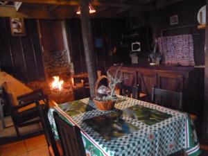 a dining room with a table and a fireplace at Lagunillas Del Poas in Poasito