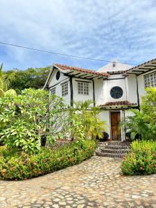 ein weißes Haus mit einer Kopfsteinpflastereinfahrt in der Unterkunft Rancho Rebecca, villa de lujo para un Max 10 personas, vistas panorámicas playa y montañas, piscina, 5 H, 5 B en Guarame, Isla de Margarita in Flandes