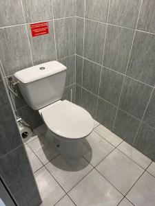 a bathroom with a white toilet in a stall at Bungalow Natura - Sarramea in Sarraméa