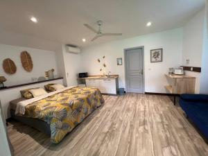 a large bedroom with a bed and a kitchen at Bungalow Natura - Sarramea in Sarraméa