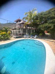 ein großer Pool vor einem Haus in der Unterkunft Rancho Rebecca, villa de lujo para un Max 10 personas, vistas panorámicas playa y montañas, piscina, 5 H, 5 B en Guarame, Isla de Margarita in Flandes