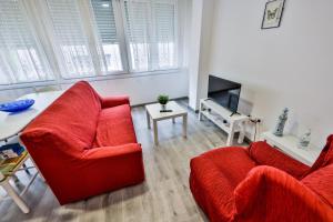 - un salon avec deux chaises rouges et une table dans l'établissement casa de Antonio, à Camariñas
