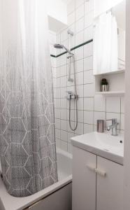 łazienka z zasłoną prysznicową i umywalką w obiekcie Cosy Appartement - 4 personnes - Disneyland & Paris w mieście Bussy-Saint-Georges