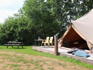 een tent met een tafel en stoelen in een veld bij Beautiful safari tent in Twijzel with terrace in Twijzel