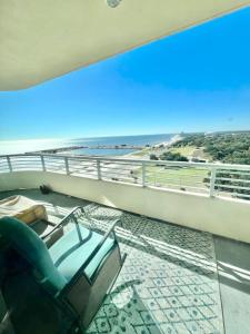 a balcony with a chair and a view of the ocean at Just Beachy Get-away in Biloxi