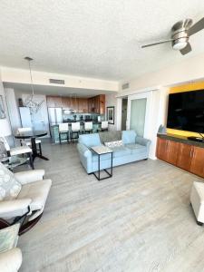 a living room with a blue couch and a kitchen at Just Beachy Get-away in Biloxi