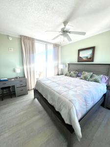 um quarto com uma cama grande e uma ventoinha de tecto em Just Beachy Get-away em Biloxi