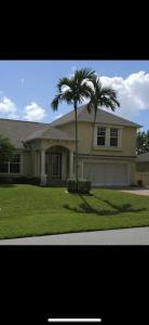 a house with two palm trees in front of it at Beautiful Home with Pool in Cape Coral