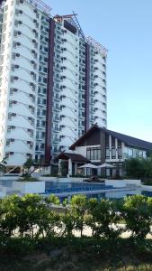 um grande edifício de apartamentos com uma piscina em frente em C&W Royal Oceancrest Mactan em Sudtungan